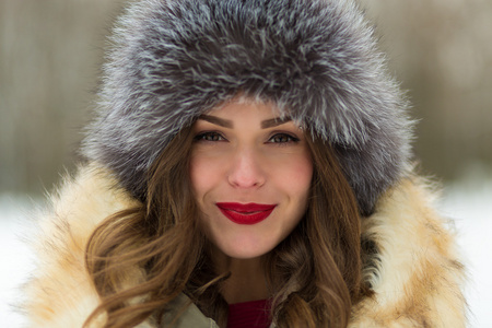 美丽的女人，在冬天的外套和毛皮帽子