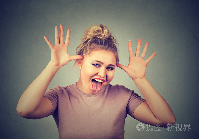 一个年轻的女人一张滑稽的脸嘲笑一个人取笑某件事