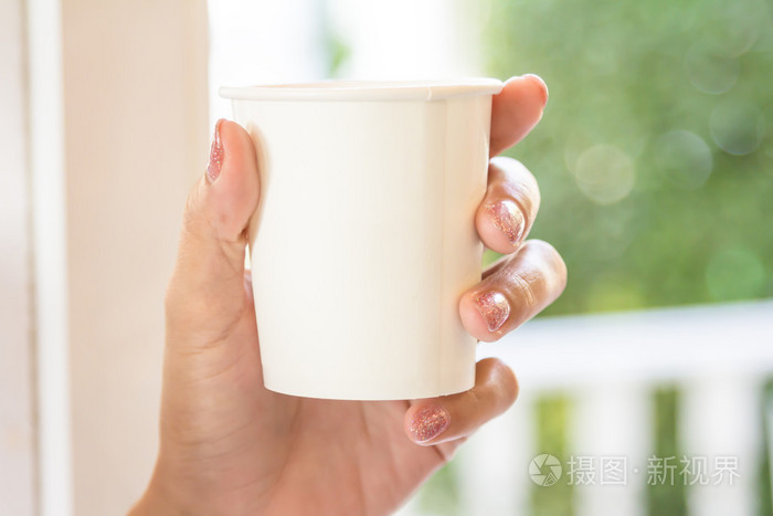 手拿着一个白色的纸杯