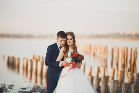 新婚夫妇，新郎，新娘花束上日落海边合影