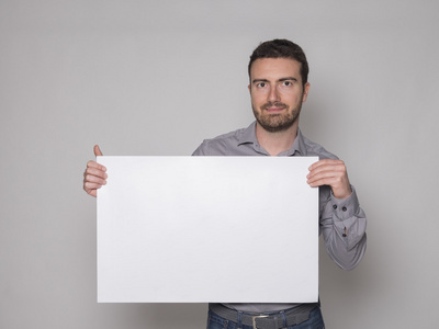 孤立在灰色的背景上的白色横幅纸板的男人
