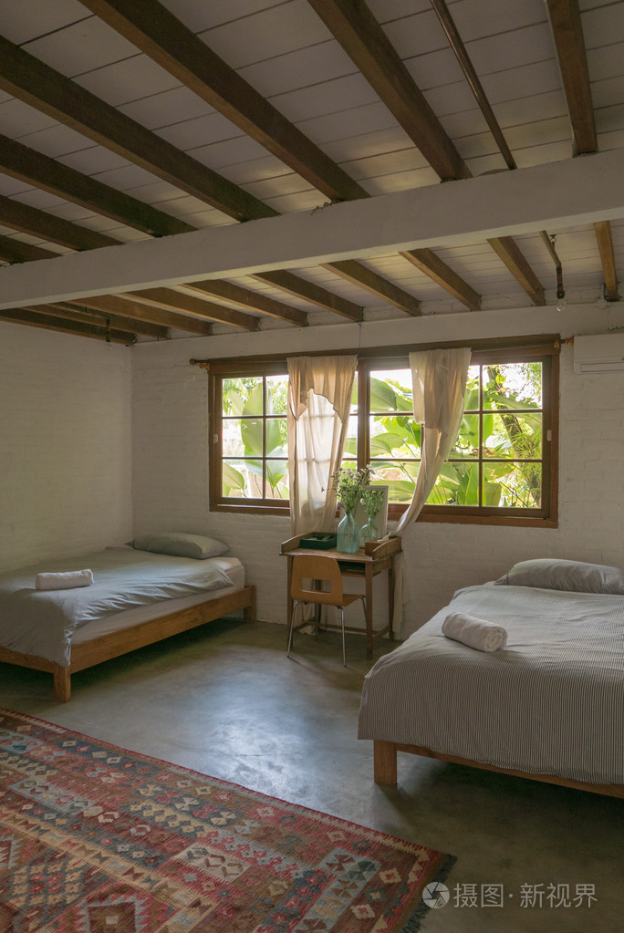 舒适明亮的睡觉的房间，木制的天花板和家具