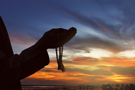 祈祷的男人的剪影手照片