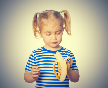 有趣的小女孩吃香蕉