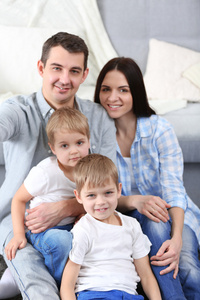 幸福的家庭坐在沙发背景特写的地板上
