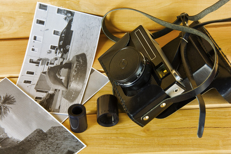 封面 照片和电影在木质表面上的老胶片相机。