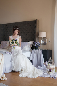 美丽的新娘穿着婚纱时用束鲜花图片