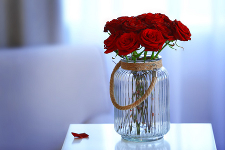 在一个玻璃瓶中的红玫瑰图片