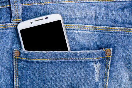在后面的口袋牛仔裤的智能手机。牛仔裤背景