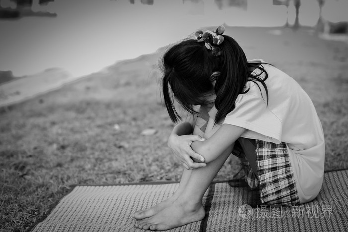 黑色和白色伤心的女孩坐在室外