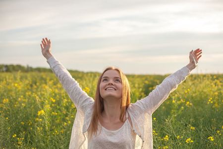 早晨时张开双臂在早晨时,绿色的试验现场的女人照片