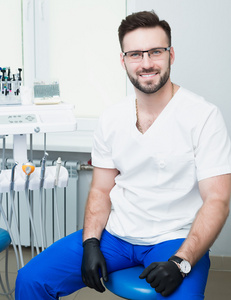 医疗 口腔医学 职业医学的概念   微笑男性年轻牙医在医疗办公室背景