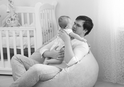 黑色和白色肖像父亲抱着他 6 个月的宝贝儿子