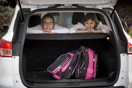 两个微笑的女生看打开汽车后备箱