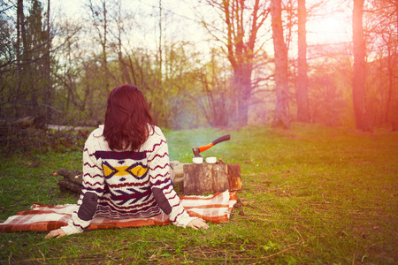 在一个温暖的毛衣，坐在火边的女孩图片