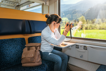女性旅行者透过火车车窗拍摄。美丽的景色，从窗户