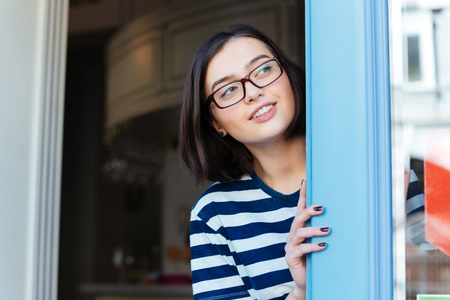 幸福的女人，戴眼镜看着外面的咖啡馆