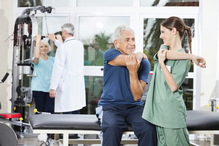 护士指导老年患者在康复中心的手臂运动