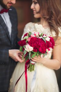 新婚夫妇拥抱，她手里拿着一束鲜花，新娘，新郎拥抱