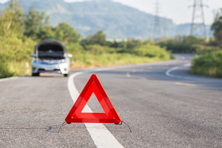 红色紧急停止标志和在道路上的破的车