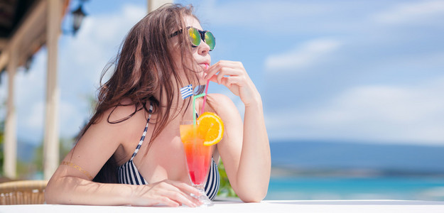 在期间热带度假海滩酒吧鸡尾酒的女人