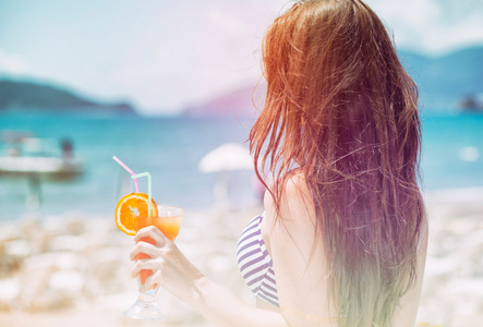 在热带度假海滩上鸡尾酒的女人
