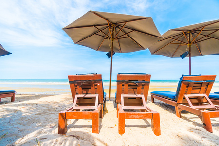 伞和坐在椅子上热带海滩