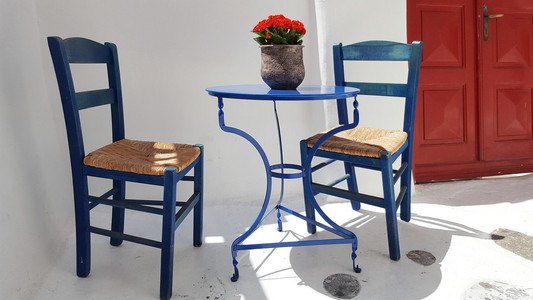 蓝色的桌子和椅子在希腊房子前面