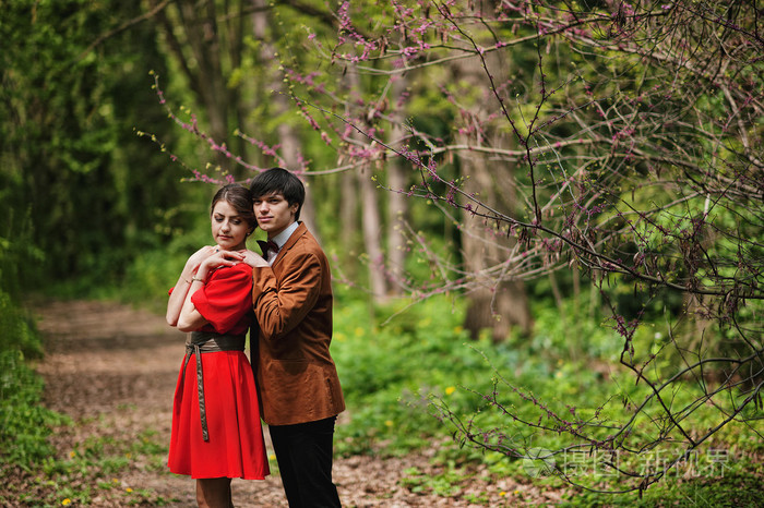 一对夫妇在森林里抱着春天的树枝时尚的男人