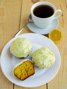 光柠檬蛋糕松饼上木制的背景和一杯茶