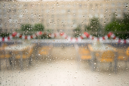 水和雨滴落在玻璃上, 在空荡荡的自助餐厅和建筑上欣赏抽象的景色