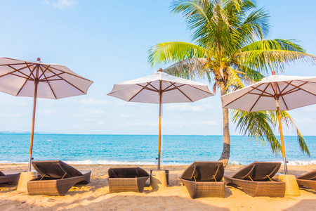 伞和坐在椅子上的美丽的热带海滩