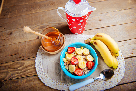 牛奶什锦早餐与新鲜草莓和香蕉特写木制的背景上。水平的顶视图