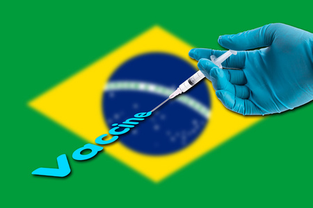 在巴西国旗背景上用蓝色手套手持注射器注射疫苗文本