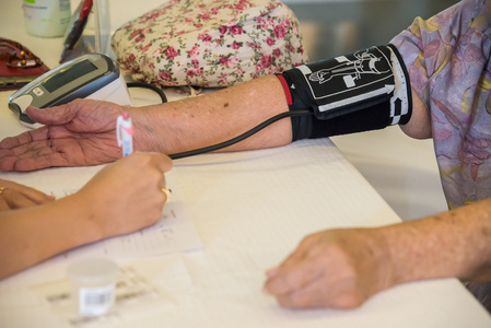 医生检查老女病人动脉血压。卫生保健