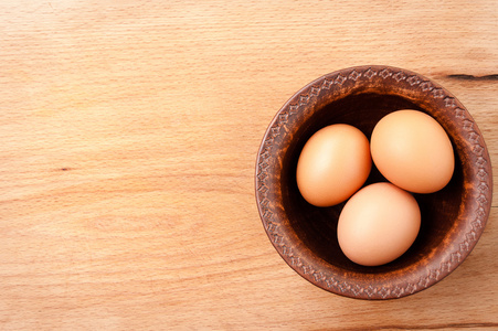 上一张小木桌，有机食品和营养食品的陶瓷碗鸡蛋