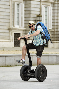 年轻的快乐游客带着背包骑车城市之旅