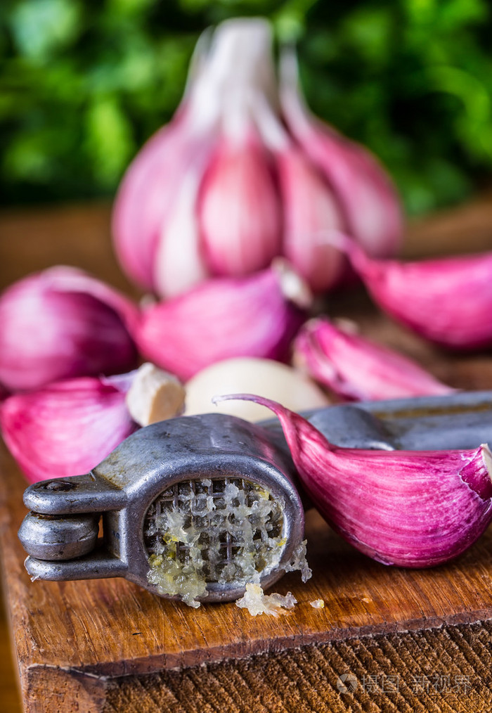 大蒜.新鲜大蒜.红皮蒜.压蒜器.紫罗兰色的大蒜.大蒜的背景.大蒜鳞茎