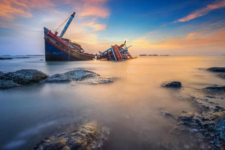 随着夕阳的天空,破船飞过大海照片
