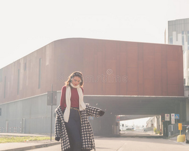 美丽的年轻黑发女郎在城市街道上摆姿势