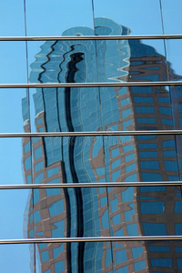 市中心的摩天大楼反射在镜面窗户上