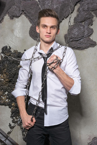 一个穿白衬衫打领带的男人打破了锁链.照片