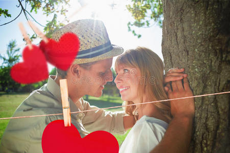 公园里一对可爱的微笑夫妇靠在树上的复合图像照片