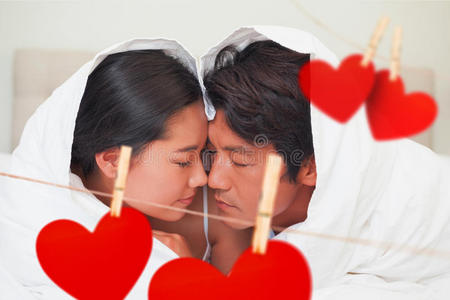 幸福夫妇躺在床上的复合图像,一起躺在羽绒被下照片