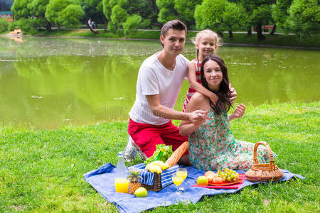 快乐的年轻一家人在户外野餐