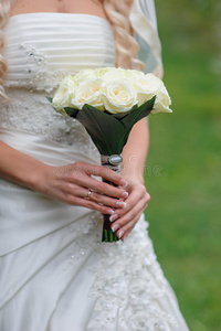 新娘拿着一束白色的婚礼花束