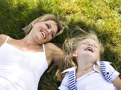 金发碧眼的母亲带着女儿在草地上玩耍