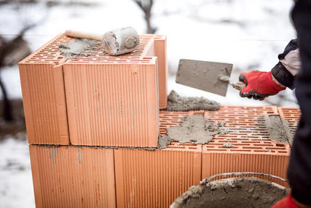 冬季新房施工现场，人用砖块和水泥工作