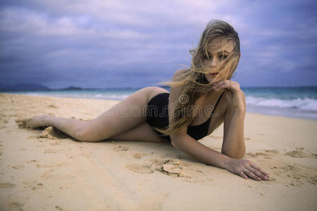 女孩懒洋洋地躺在沙滩上