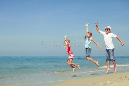 父亲和女儿白天在海滩上玩耍。